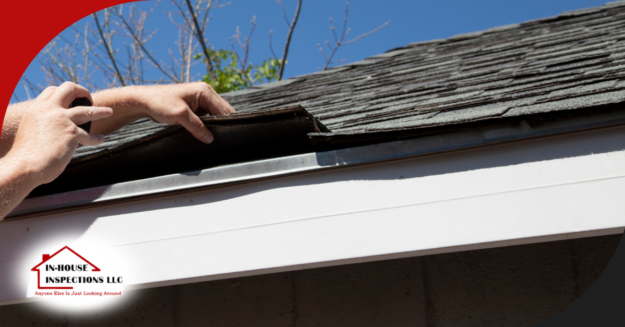 In-House Inspections LLC Inspecting roof shingles at the eaves with hands lifting the material.