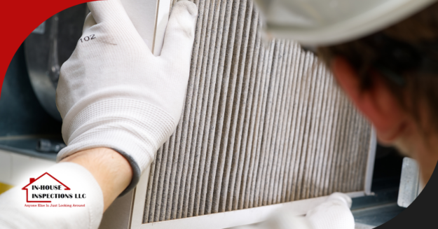 In-House Inspections LLC Technician replacing an air filter in an HVAC system during an inspection.