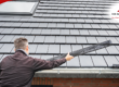 Inspector installing a gutter guard on a roof.