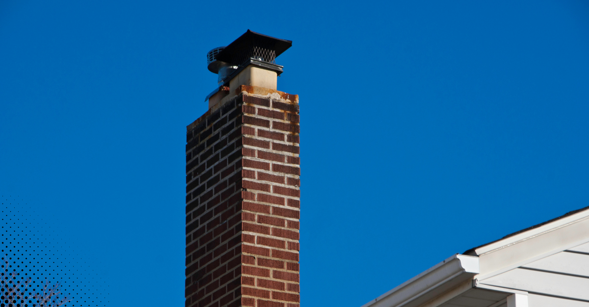 Brick chimney with a chimney cap against a blue sky